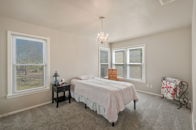 carpeted bedroom with baseboards and an inviting chandelier