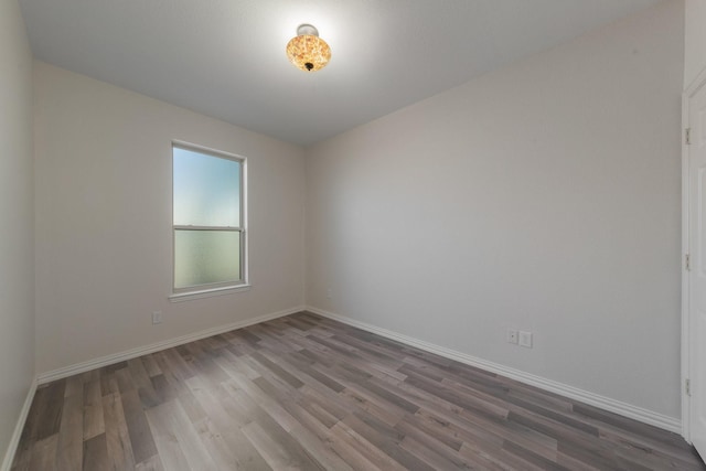 empty room with baseboards and wood finished floors