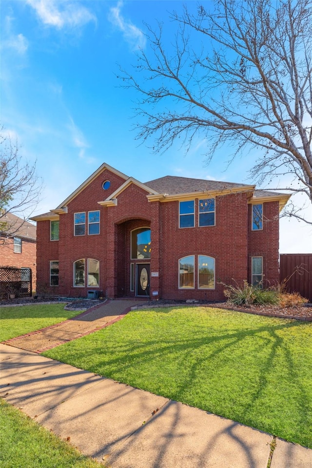 view of front of property with a front yard, fence, and brick siding