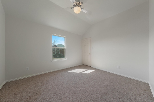 spare room featuring a ceiling fan, light colored carpet, vaulted ceiling, and baseboards