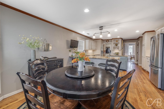 dining space featuring crown molding, recessed lighting, baseboards, and light wood-style floors