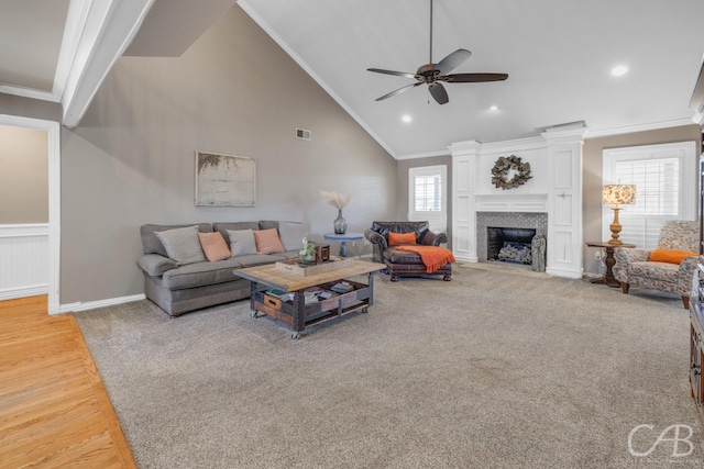 carpeted living room featuring ornamental molding, plenty of natural light, and visible vents