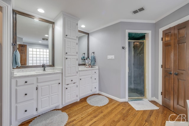 full bathroom featuring baseboards, visible vents, ornamental molding, wood finished floors, and a shower stall