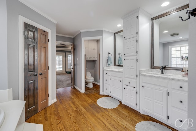 full bath featuring ornamental molding, a wealth of natural light, toilet, and wood finished floors