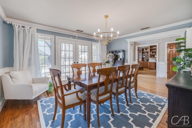 dining space featuring ornamental molding, french doors, visible vents, and wood finished floors