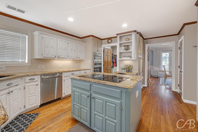 kitchen featuring visible vents, white cabinets, dishwasher, a center island, and black electric stovetop