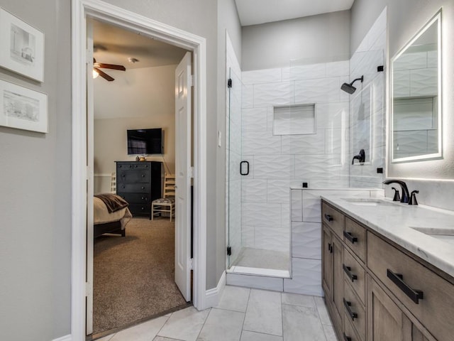 bathroom with double vanity, a shower stall, ceiling fan, and a sink