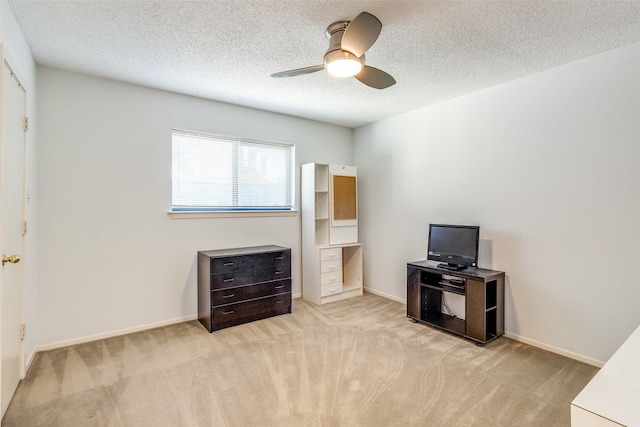 bedroom featuring light carpet, ceiling fan, baseboards, and a textured ceiling