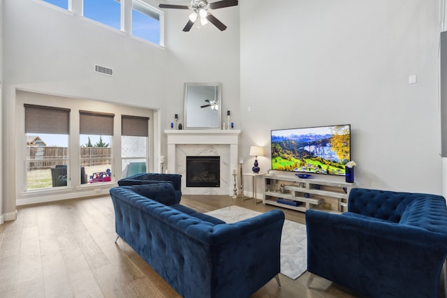 1600 Pebblebrook Ln, Prosper, TX 75078 - living area featuring visible vents, ceiling fan, a high end fireplace, wood finished floors, and a towering ceiling