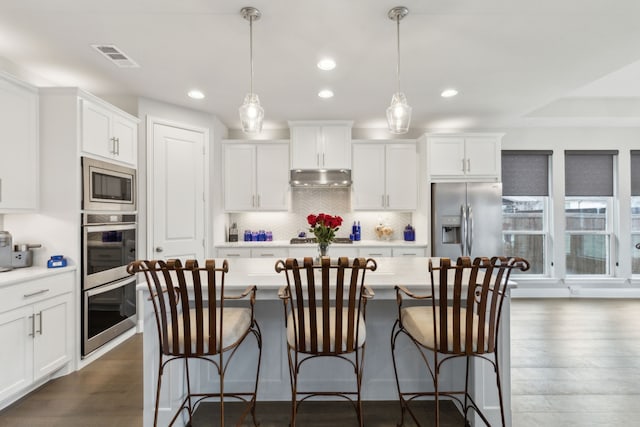 1600 Pebblebrook Ln, Prosper, TX 75078 - kitchen with stainless steel appliances, under cabinet range hood, light countertops, and a kitchen island