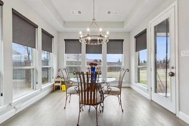 1600 Pebblebrook Ln, Prosper, TX 75078 - dining space with a chandelier, visible vents, a tray ceiling, and wood finished floors