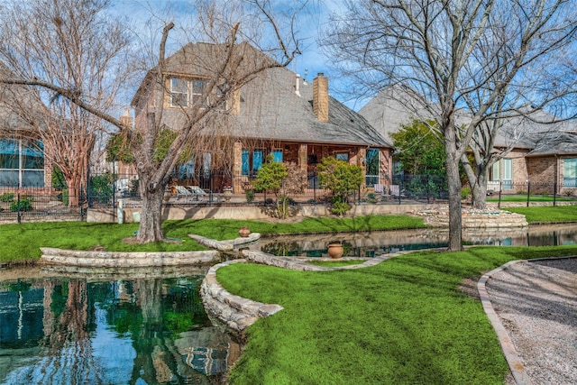 rear view of property with a yard, a chimney, and fence