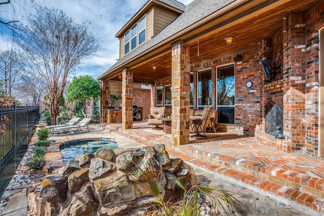 view of patio / terrace with fence and an in ground hot tub