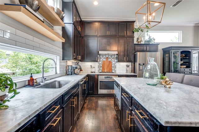 kitchen with appliances with stainless steel finishes, backsplash, a sink, and visible vents