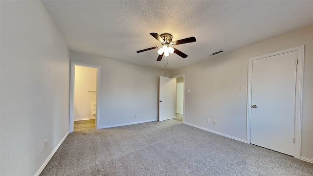 unfurnished bedroom featuring a textured ceiling, carpet, visible vents, and baseboards