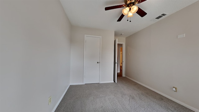 unfurnished bedroom featuring light carpet, ceiling fan, visible vents, and baseboards