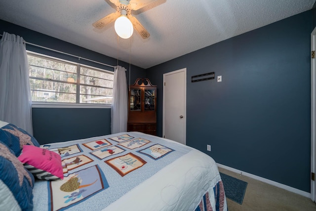 bedroom with ceiling fan, a textured ceiling, baseboards, and carpet flooring