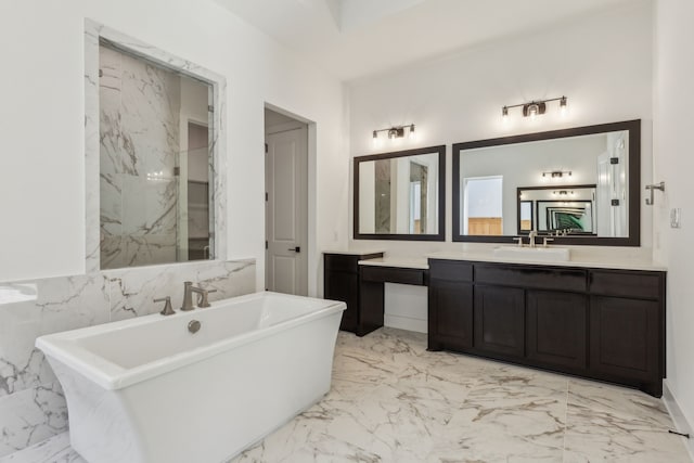 bathroom with marble finish floor, a freestanding tub, and vanity