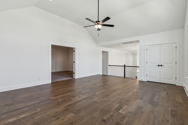 empty room with baseboards, visible vents, a ceiling fan, dark wood-style flooring, and high vaulted ceiling