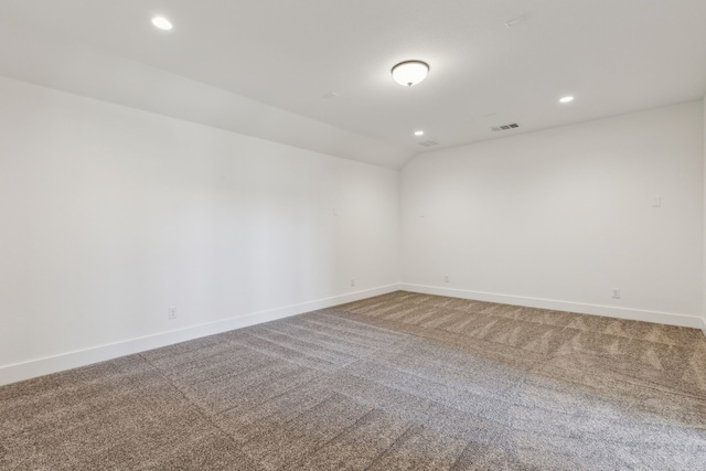 empty room with baseboards, visible vents, vaulted ceiling, carpet flooring, and recessed lighting