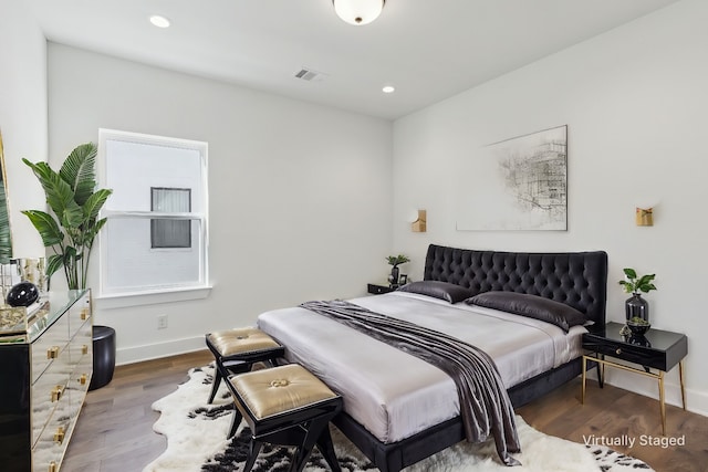 bedroom with recessed lighting, visible vents, baseboards, and wood finished floors