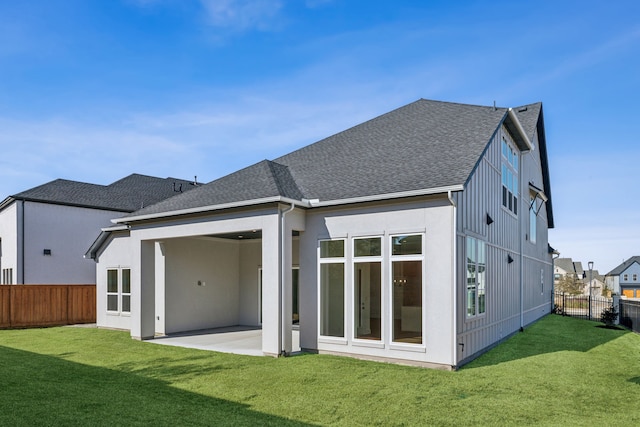 back of house with a patio area, a fenced backyard, a shingled roof, and a lawn