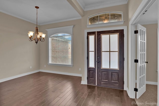 entrance foyer featuring baseboards, ornamental molding, dark wood-style flooring, and a notable chandelier