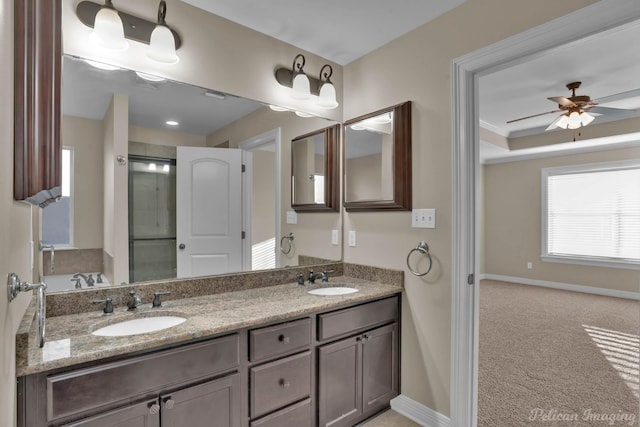 bathroom featuring a ceiling fan, a raised ceiling, a sink, and baseboards