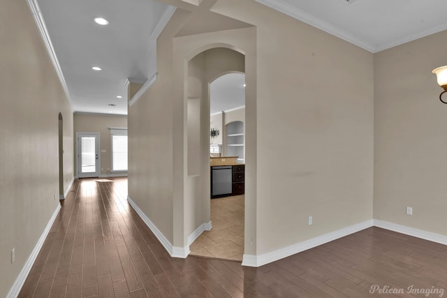 hall with dark wood-style floors, arched walkways, and crown molding