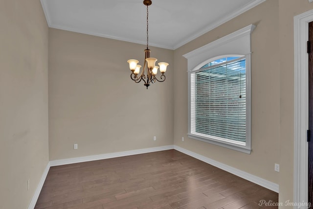 unfurnished room with an inviting chandelier, baseboards, dark wood-style flooring, and crown molding