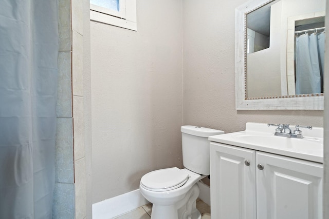 bathroom with a textured wall, toilet, tile patterned floors, curtained shower, and vanity