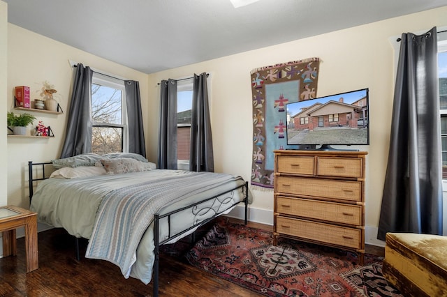 bedroom with dark wood-style flooring and baseboards