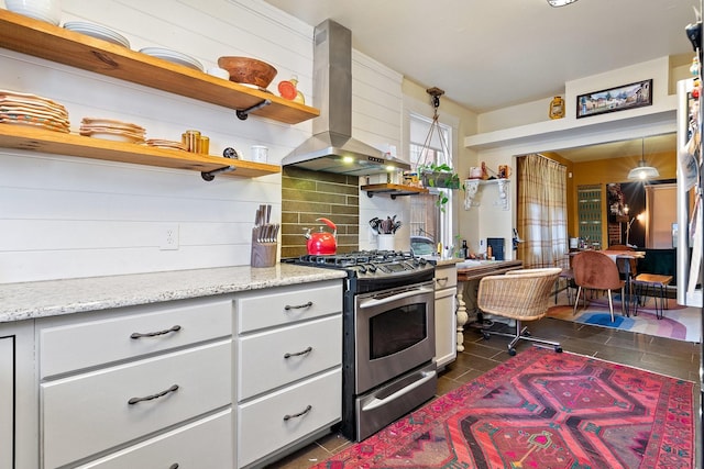 kitchen featuring open shelves, decorative backsplash, white cabinetry, wall chimney range hood, and stainless steel gas range oven