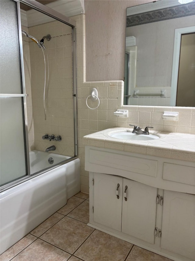 full bathroom with vanity, combined bath / shower with glass door, tile walls, and tile patterned floors