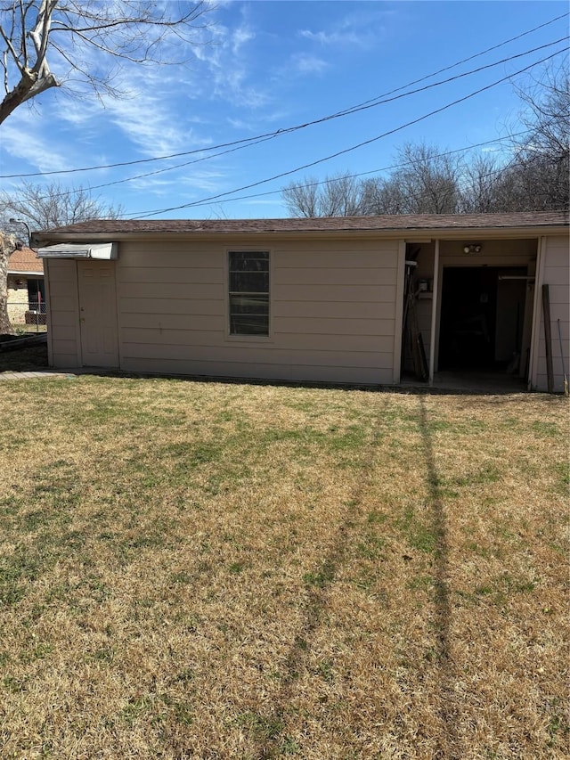 back of house with a yard and an outdoor structure