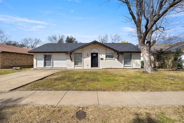 view of front of house featuring a shingled roof and a front lawn