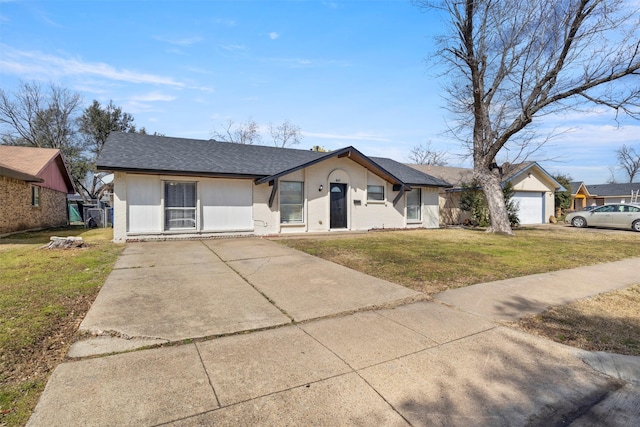 view of front of home with a garage, roof with shingles, concrete driveway, and a front yard