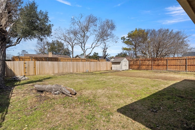 view of yard with a fenced backyard, an outdoor structure, and a storage unit