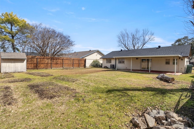 view of yard with a storage shed, fence, a patio, and an outbuilding