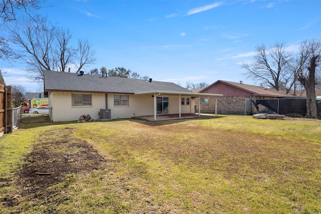 rear view of property with a yard, central AC unit, a patio, and a fenced backyard