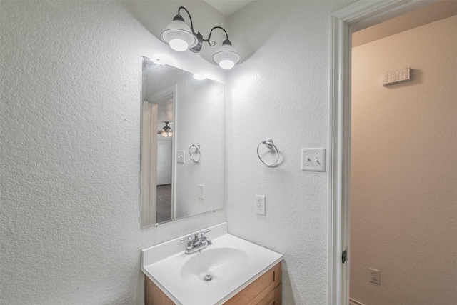 bathroom with a textured wall and vanity