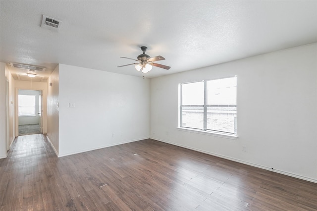 empty room with visible vents, wood finished floors, and attic access