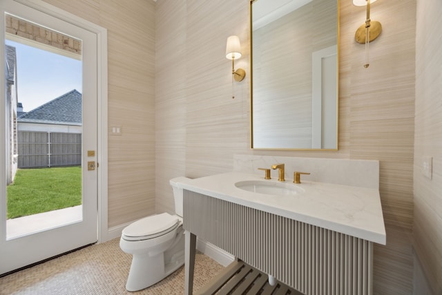 half bath with a wealth of natural light, vanity, and toilet