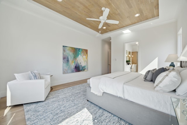 bedroom with a tray ceiling, recessed lighting, wood finished floors, wooden ceiling, and baseboards