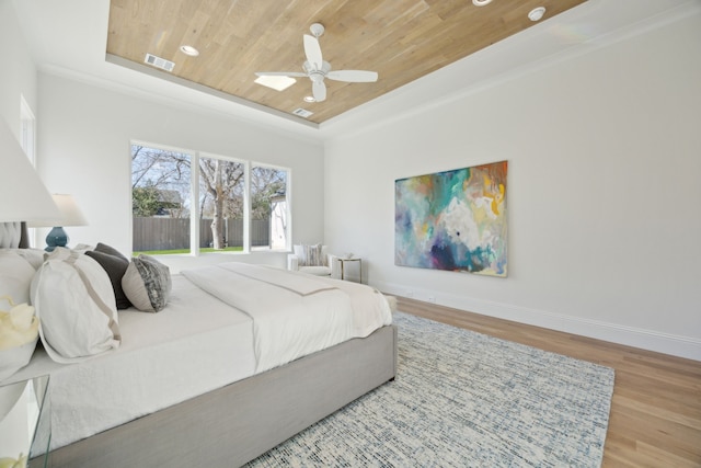 bedroom featuring visible vents, baseboards, wood ceiling, wood finished floors, and a tray ceiling