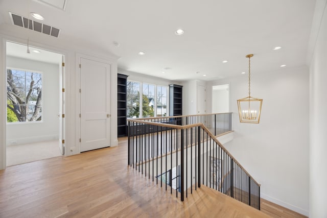 hallway featuring baseboards, light wood-style floors, visible vents, and recessed lighting