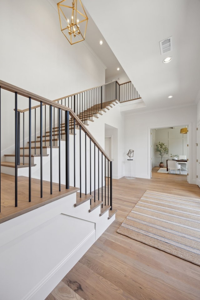 stairs featuring visible vents, a chandelier, wood finished floors, and recessed lighting