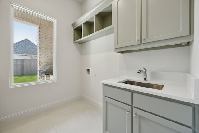 washroom featuring a healthy amount of sunlight, cabinet space, washer hookup, and a sink