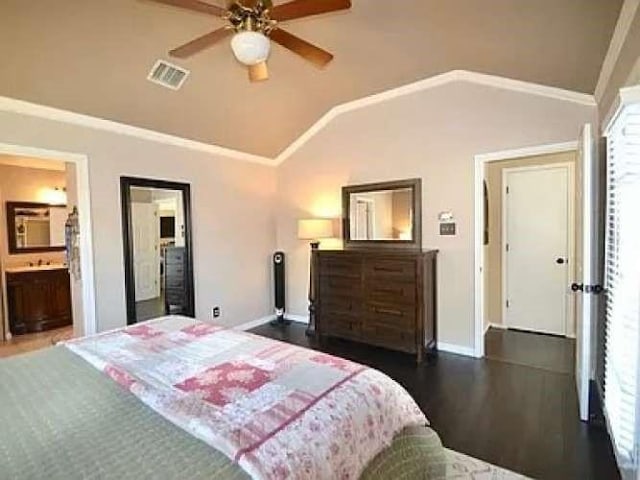 bedroom featuring lofted ceiling, wood finished floors, visible vents, baseboards, and crown molding