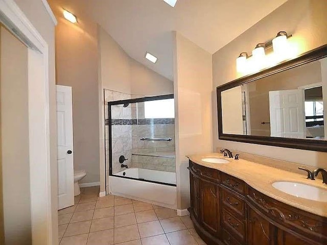 full bath featuring toilet, tile patterned flooring, a sink, and lofted ceiling